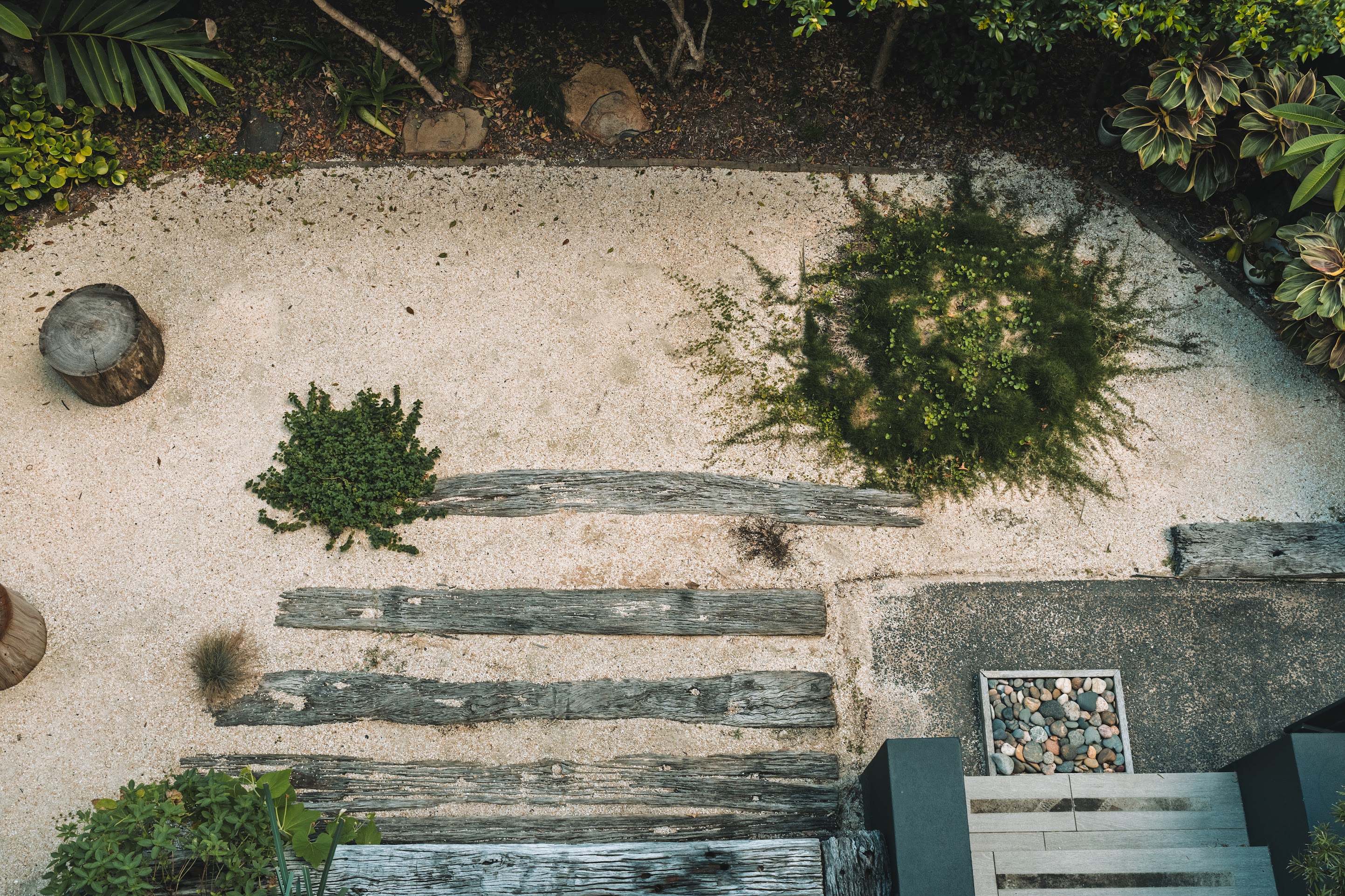 A coastal garden that features a fire pit area, a small veggie garden, welcomes the light without compromising the privacy