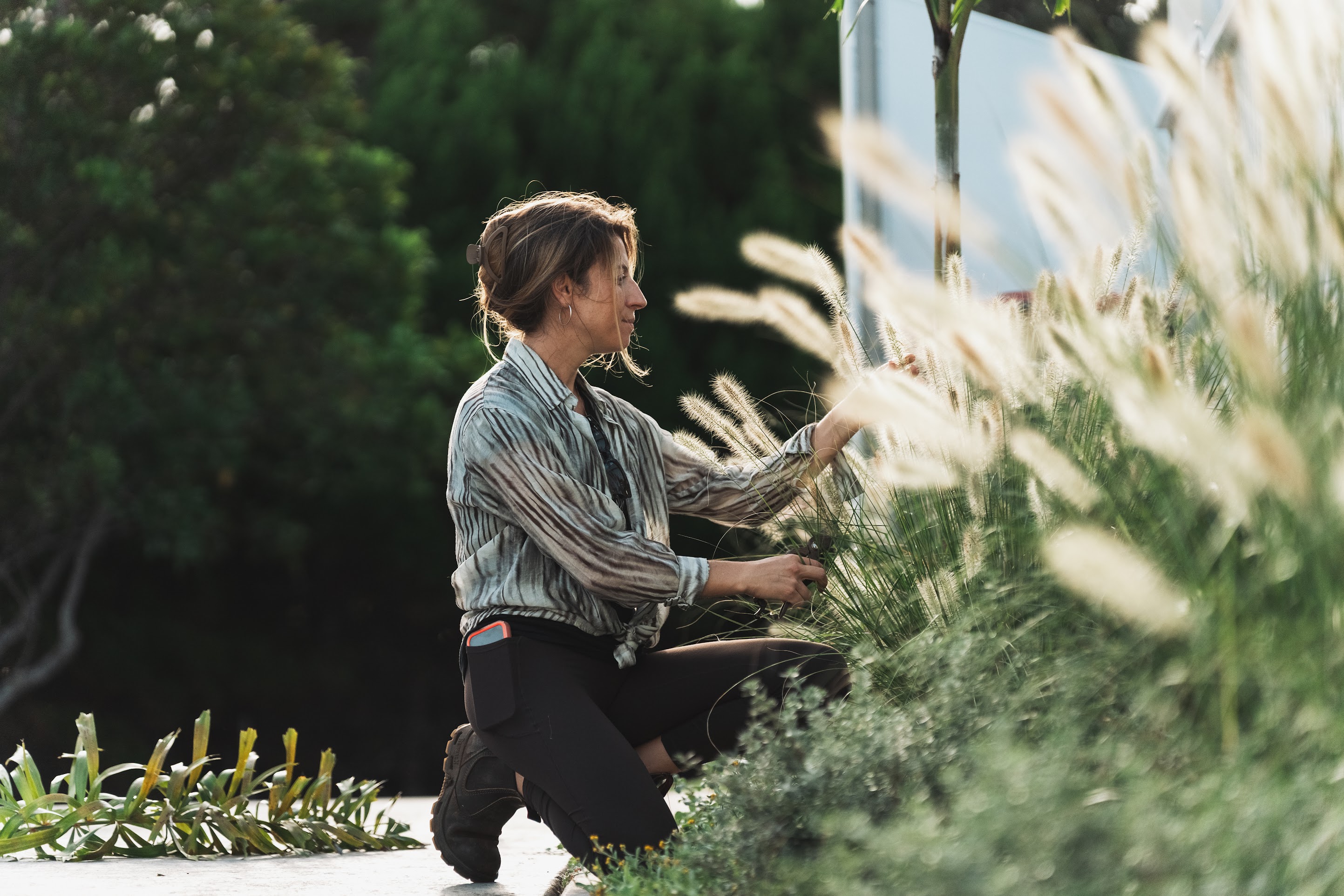 Margarida, the landscape designer behind Balga Designs, planting in a garden